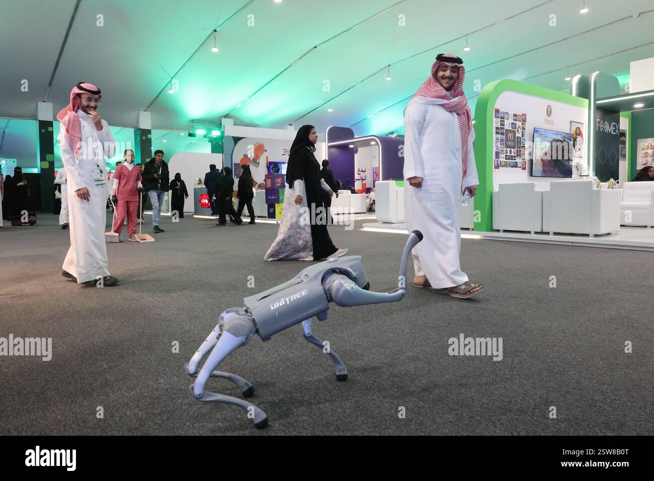 Riyad, Arabie Saoudite. 20 février 2025. Les gens regardent la performance d'un chien robot lancé par la société chinoise Unitree Robotics, à l'exposition future of Media à Riyad, en Arabie Saoudite, le 20 février 2025. Une foule animée a souvent éclaté dans les acclamations et les rires, alors qu'un chien robot chinois captivait les spectateurs avec ses mouvements de danse lors de l'exposition future of Media, qui s'est tenue parallèlement au Forum des médias saoudien à Riyad du mercredi au vendredi. Crédit : Yin Ke/Xinhua/Alamy Live News Banque D'Images Riyad, Arabie Saoudite. 20 février 2025. Les gens regardent la performance d'un chien robot lancé par la société chinoise Unitree Robotics, à l'exposition future of Media à Riyad, en Arabie Saoudite, le 20 février 2025. Une foule animée a souvent éclaté dans les acclamations et les rires, alors qu'un chien robot chinois captivait les spectateurs avec ses mouvements de danse lors de l'exposition future of Media, qui s'est tenue parallèlement au Forum des médias saoudien à Riyad du mercredi au vendredi. Crédit : Yin Ke/Xinhua/Alamy Live News Banque D'Images