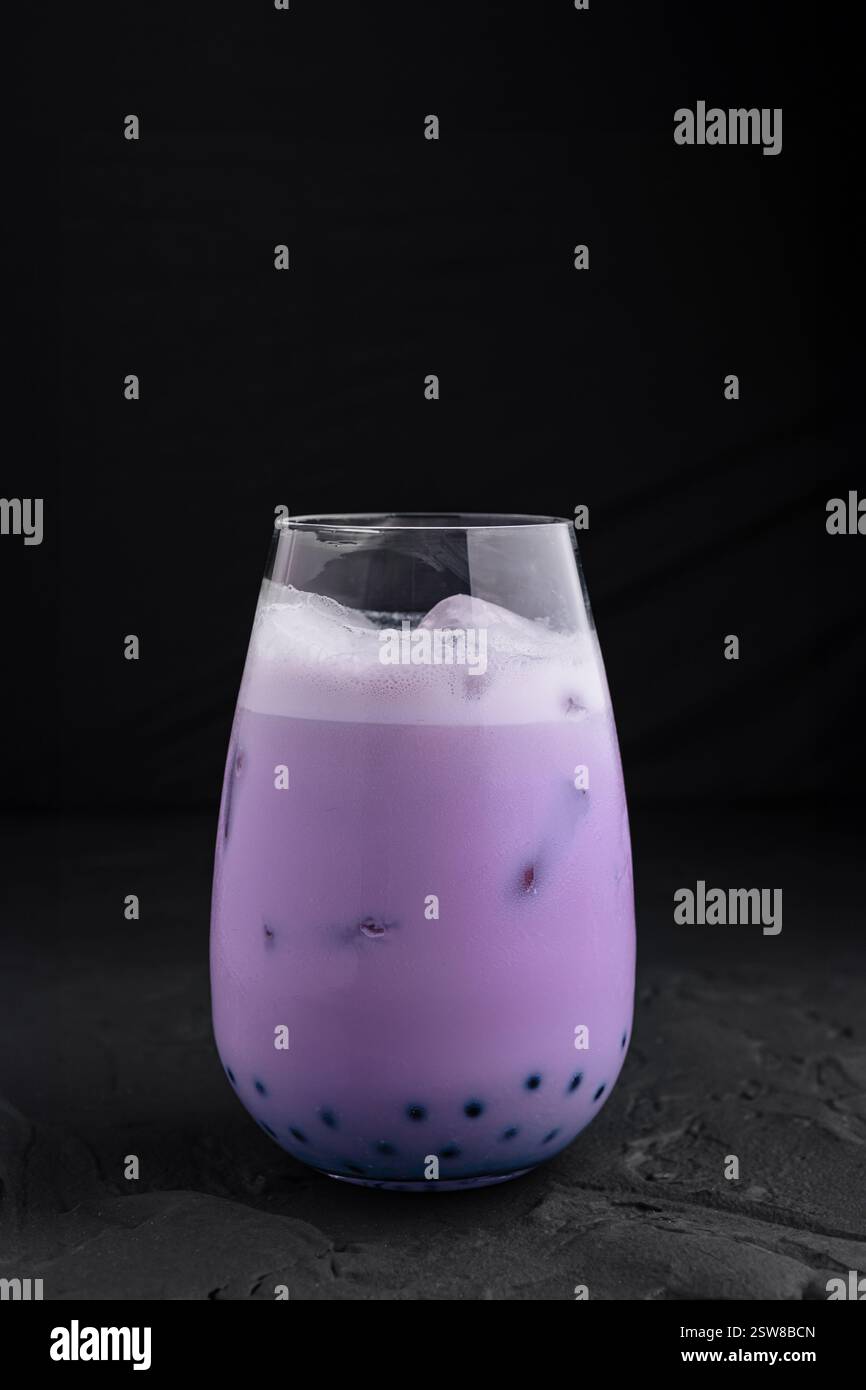 Thé à bulles taro violet debout sur fond sombre Banque D'Images