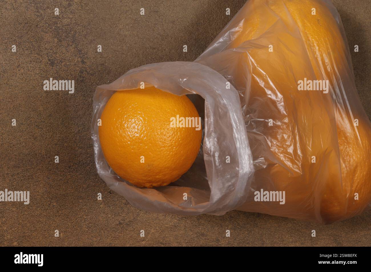 Un sac en plastique, comme un récipient, est rempli d'oranges. Banque D'Images
