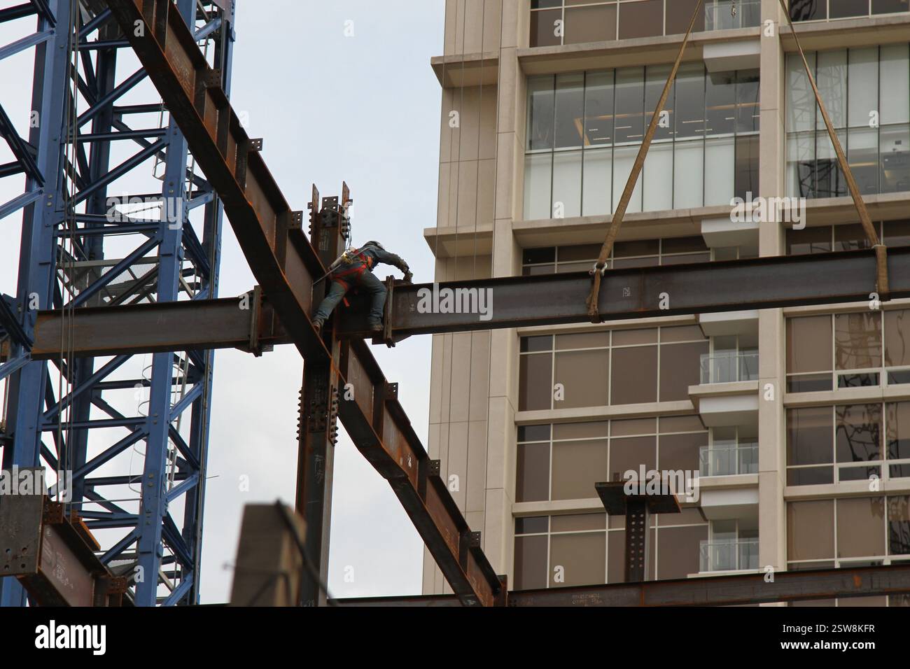 Un ouvrier de la construction marchant sur le bord d'une poutre en acier. Banque D'Images