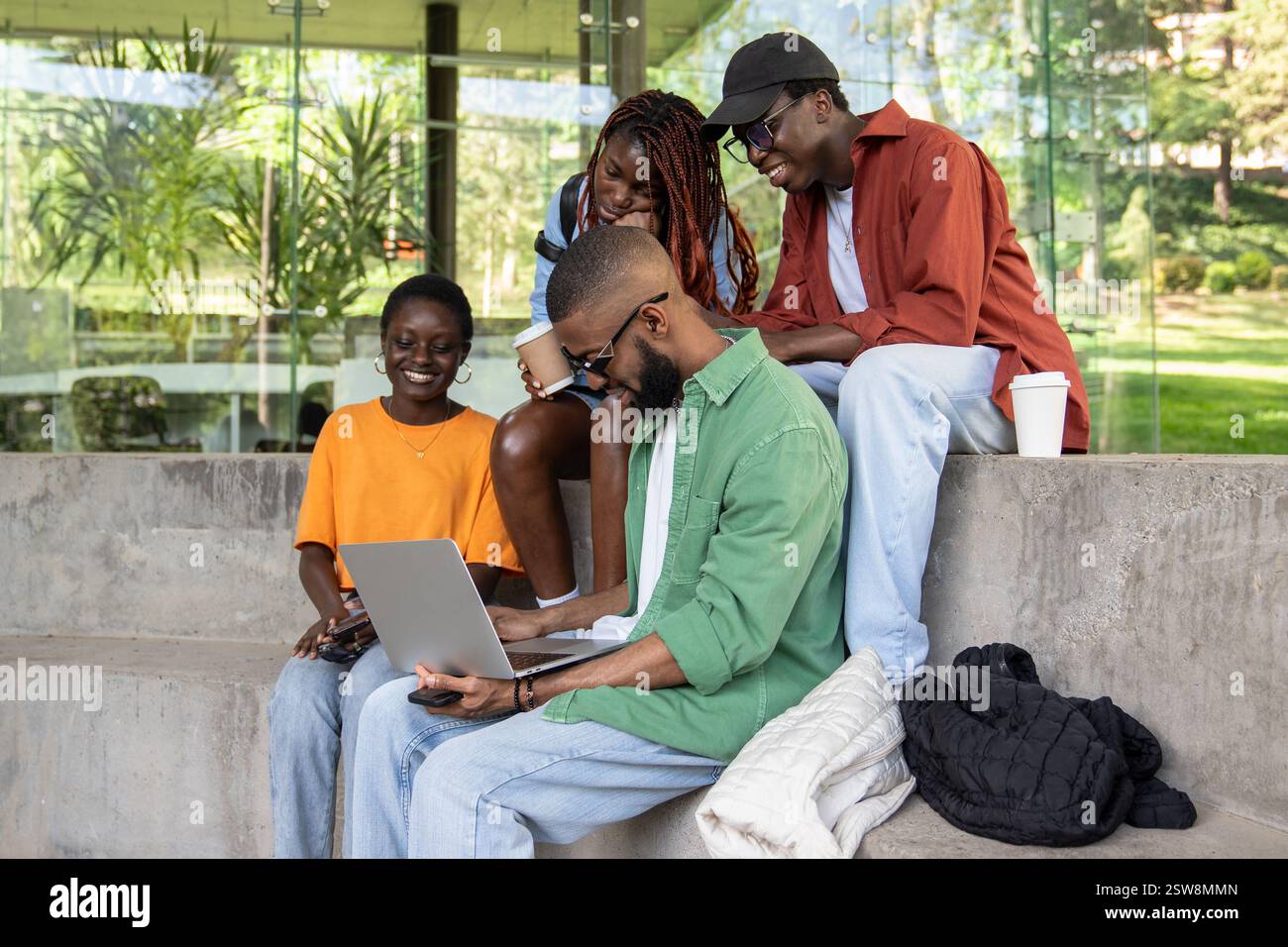 Compagnie d'étudiants afro-américains heureux satisfaits étudiant à l'extérieur à l'aide d'un ordinateur portable. Banque D'Images