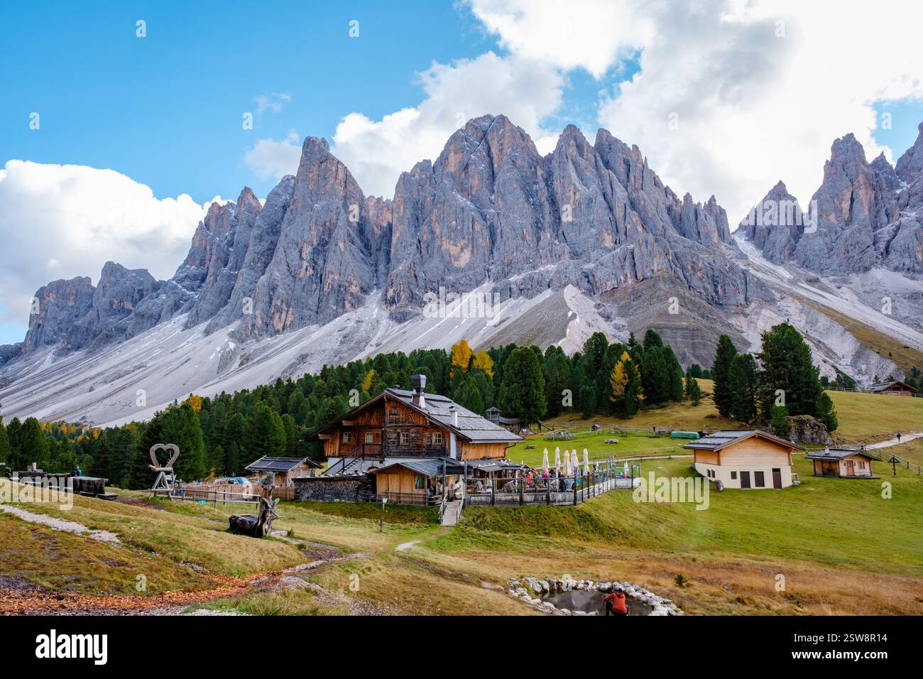 Paysage majestueux des Dolomites avec des chalets rustiques sous un ciel spectaculaire en Italie Banque D'Images