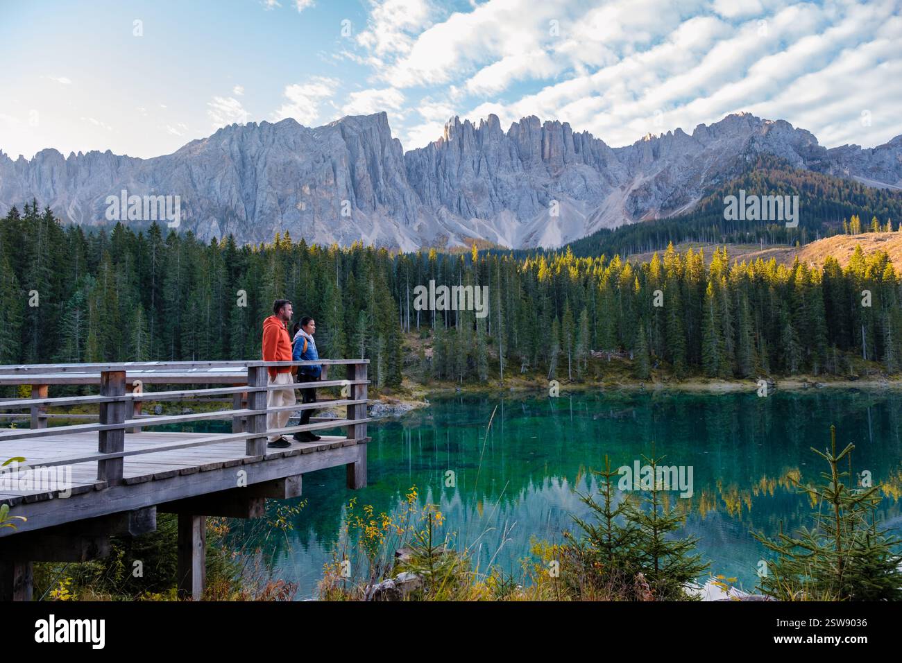 Les majestueuses Dolomites se reflètent dans le lac serein tandis que les randonneurs admirent le paysage magnifique Banque D'Images