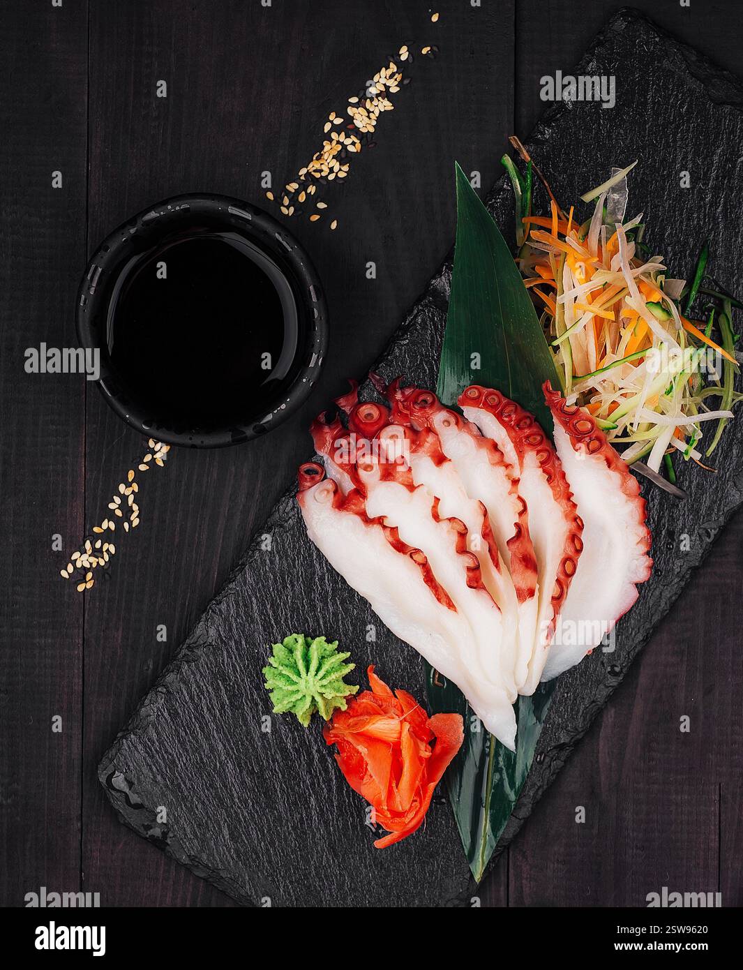 Sashimi de poulpe tranché avec sauce soja et wasabi sur un plateau de service en ardoise Banque D'Images Sashimi de poulpe tranché avec sauce soja et wasabi sur un plateau de service en ardoise Banque D'Images