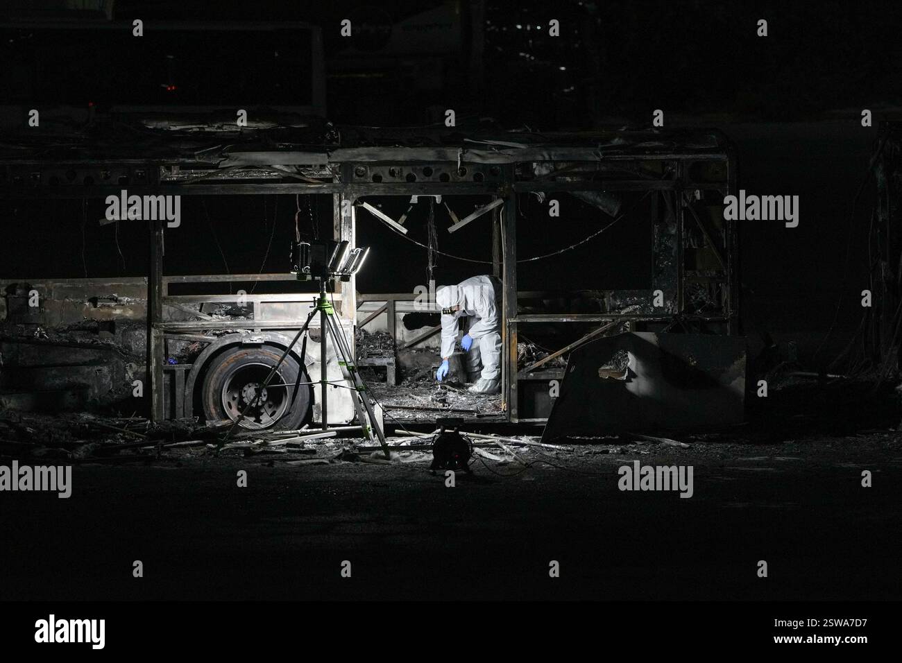 An Israeli police officer inspects the scene of one of a series of bus explosions in what authorities said appeared to be a militant attack in Bat Yam, central Israel, Thursday, Feb. 20, 2025. (AP Photo/Ohad Zwigenberg) Banque D'Images