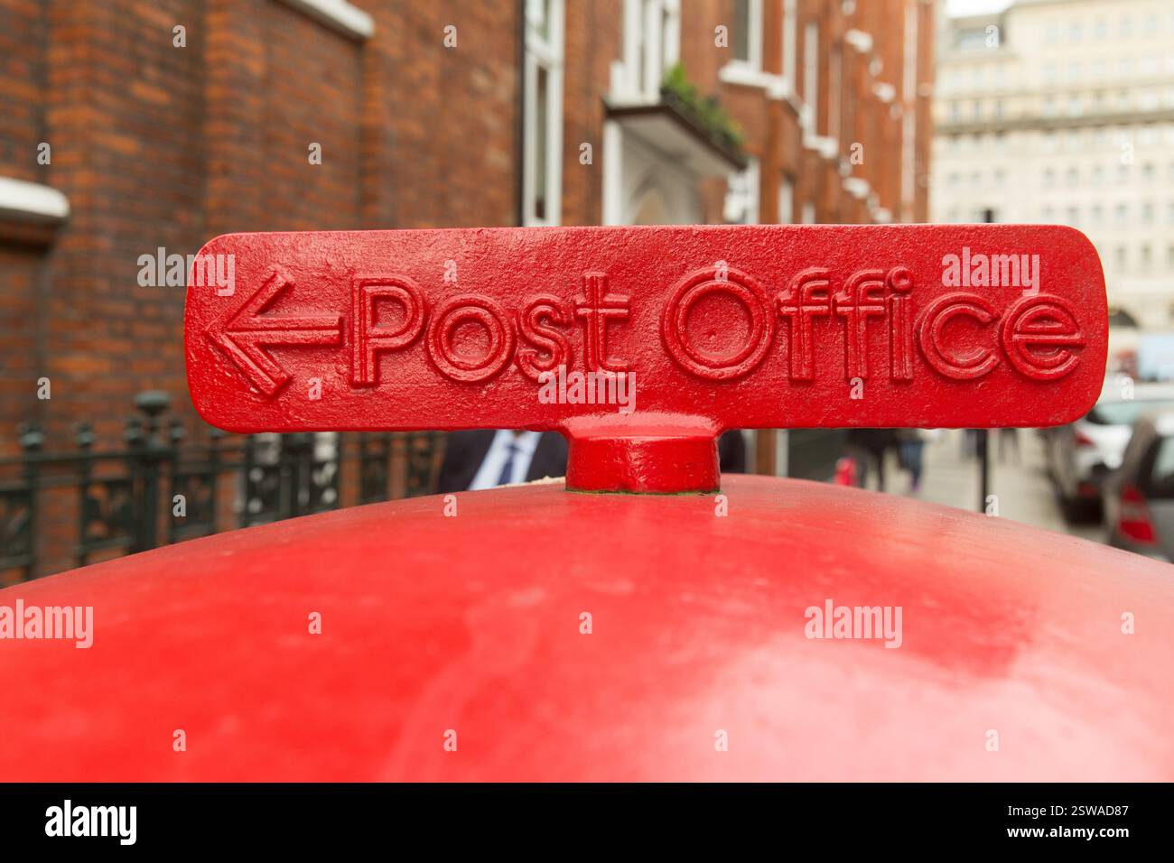 Boîte postale rouge, indiquant le bureau de poste, dans une rue londonienne. Probablement près des bâtiments en briques. Banque D'Images