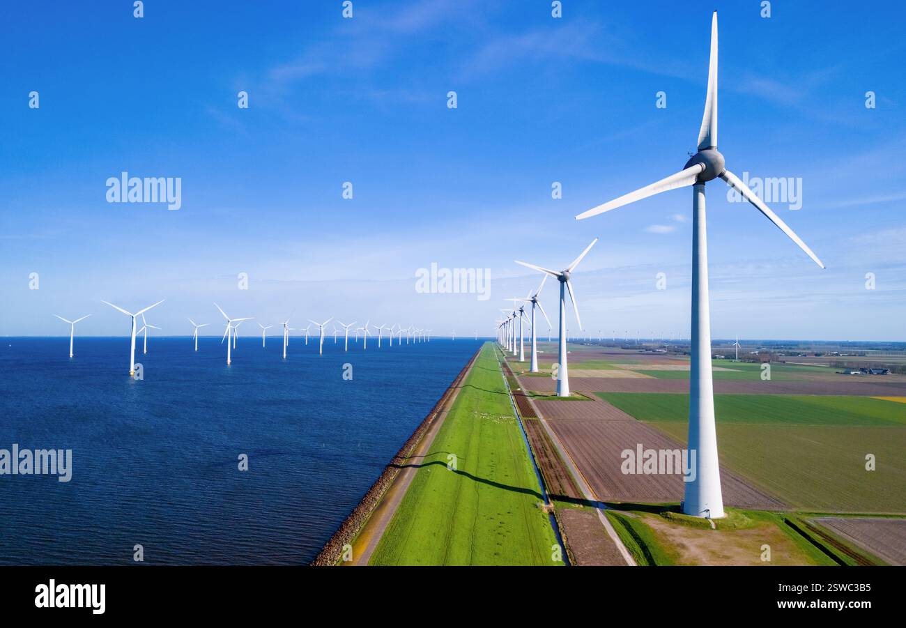 Un paysage serein où une rangée d'éoliennes se dresse à côté d'un plan d'eau tranquille dans les pays-Bas Flevoland pendant Banque D'Images