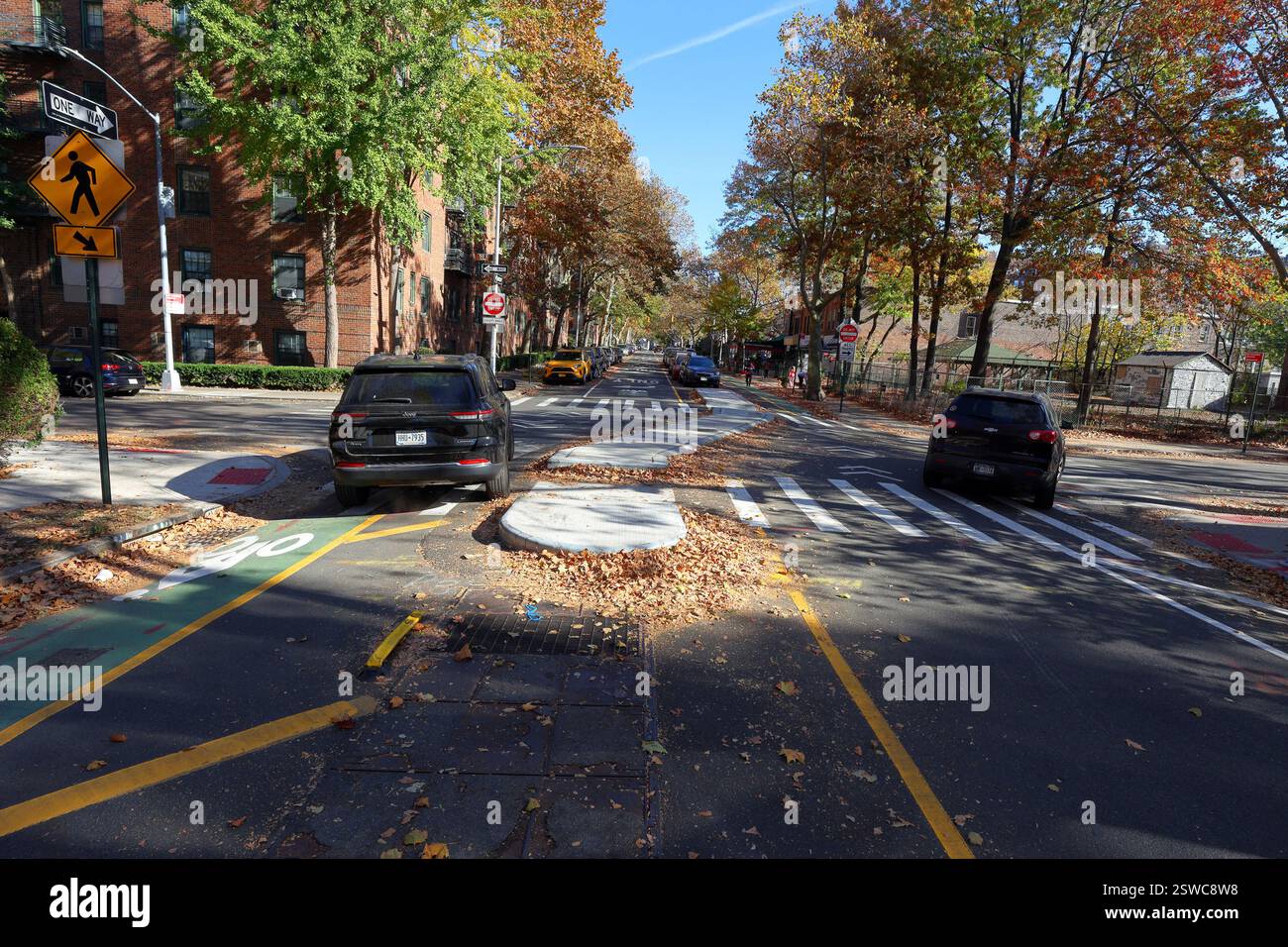 Un automobiliste conduisant sur une piste cyclable, faisant un virage à gauche illégal à un déviateur de virage forcé à 50 St et 39 Ave dans le Queens, New York City Banque D'Images