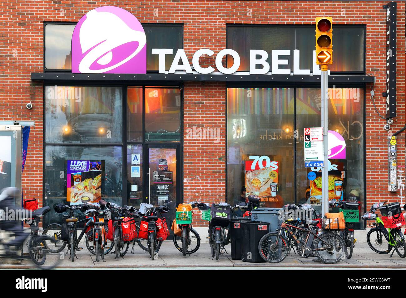 DoorDash, GrubHub, Uber mange des vélos électriques de livraison de nourriture devant un Taco Bell à New York. Banque D'Images