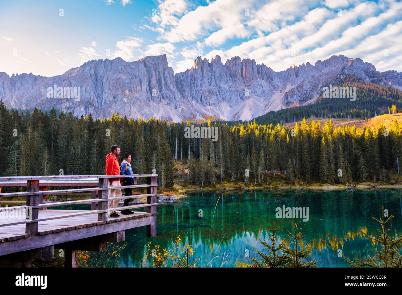 Les majestueuses Dolomites se reflètent dans le lac serein tandis que les randonneurs admirent le paysage magnifique Banque D'Images