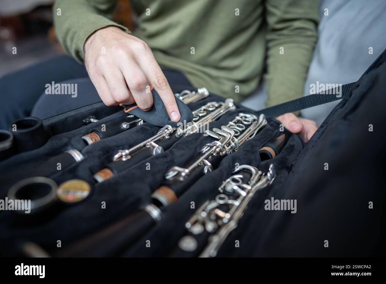 Mains prudentes nettoyer la clarinette avec un chiffon doux, en enlevant les traces d'utilisation pendant que l'instrument repose dans le boîtier Banque D'Images