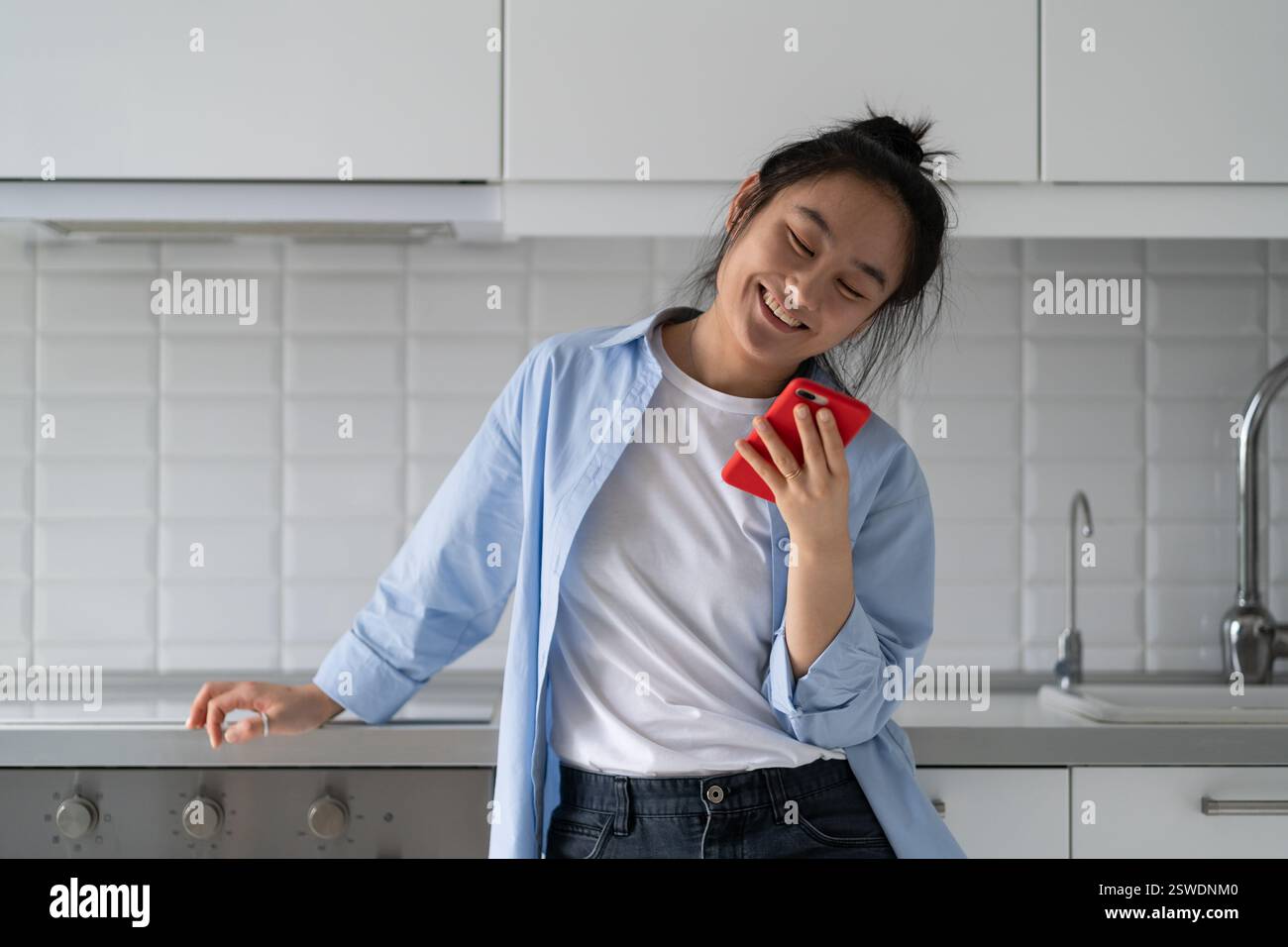 J'ai été impressionnée par les femmes asiatiques avec le téléphone et le sourire après avoir lu un message mignon de mon petit ami Banque D'Images