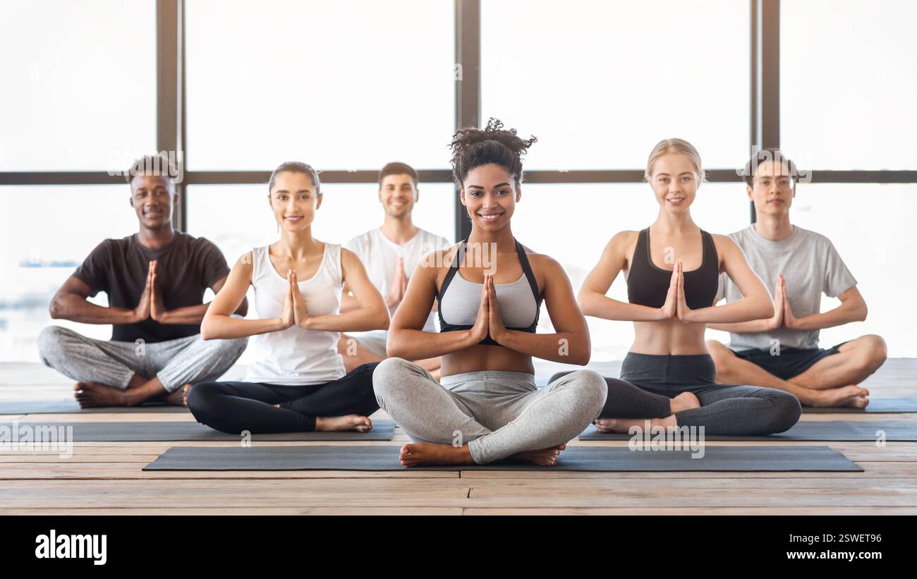 Concept de bien-être. Jeunes heureux pratiquant le yoga dans Modern Light Studio Banque D'Images