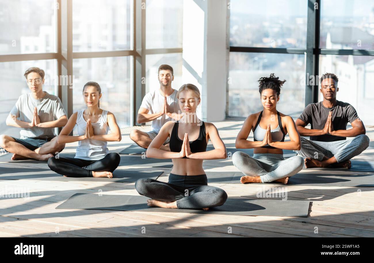 Séance de yoga. Les jeunes font de la méditation de groupe dans un studio moderne Banque D'Images