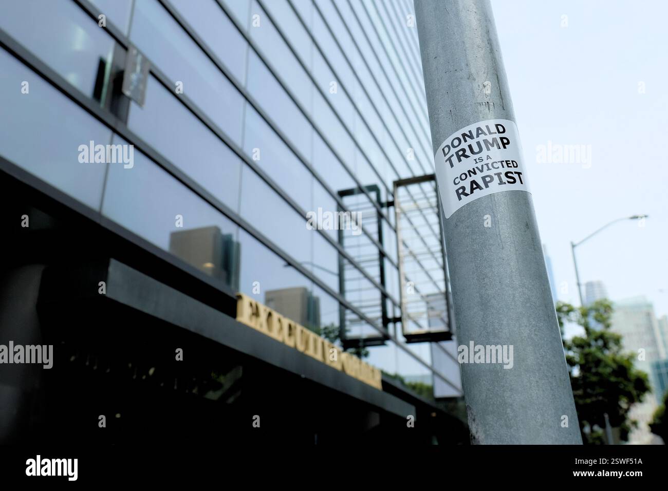 Autocollant indiquant « Donald Trump est un violeur reconnu coupable » sur un poteau métallique dans le centre de San Francisco, Californie ; commentaire politique public. Banque D'Images