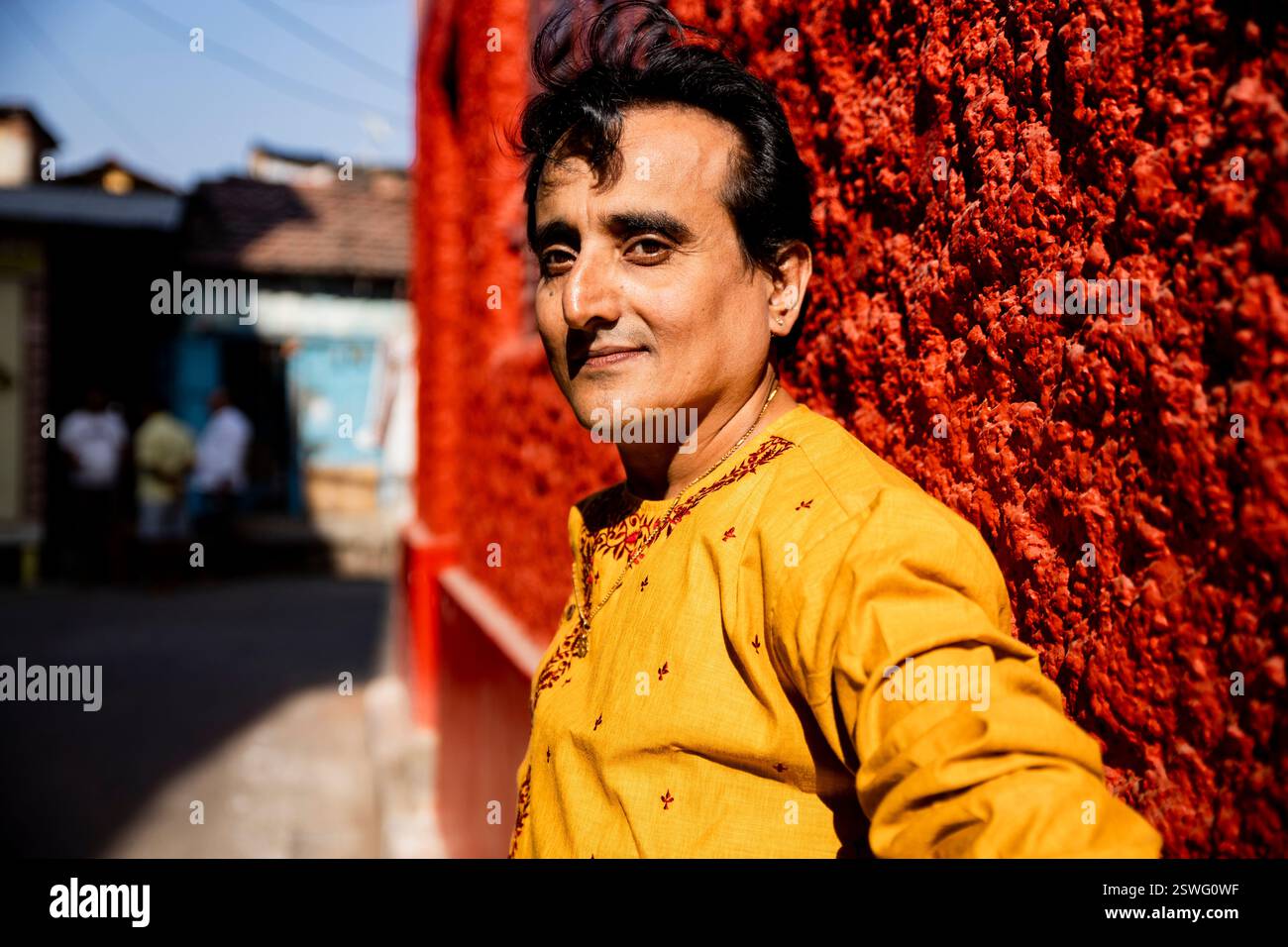 Un indien portant un dhoti rouge bengali traditionnel indien et kurta orange posant en plein air dans les rues de kolkata Banque D'Images