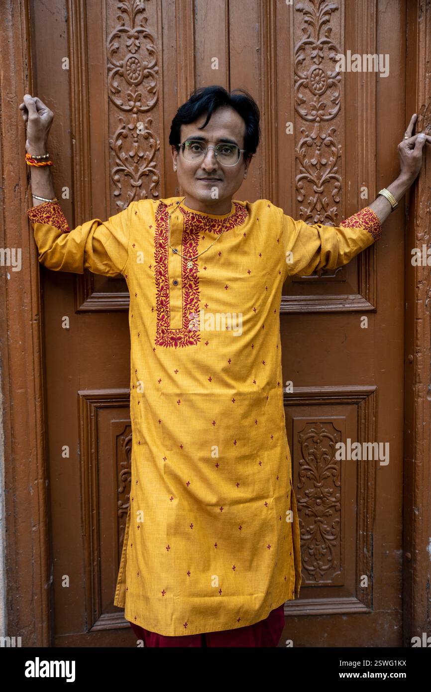 Un indien portant un dhoti rouge bengali traditionnel indien et kurta orange posant en plein air dans les rues de kolkata Banque D'Images