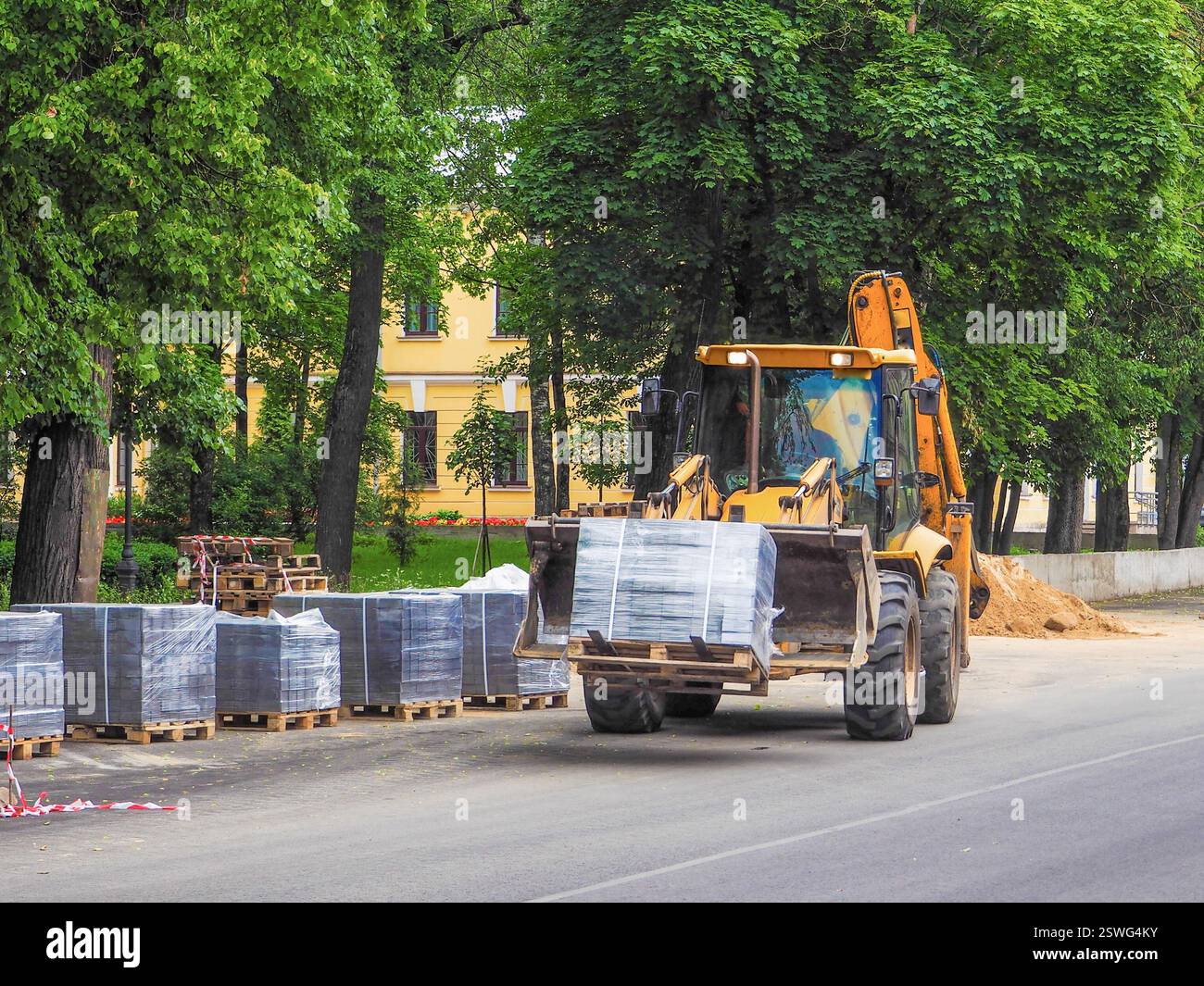 Le tracteur transporte les unités d'emballage. Travaux routiers. L'amélioration de la ville. Banque D'Images