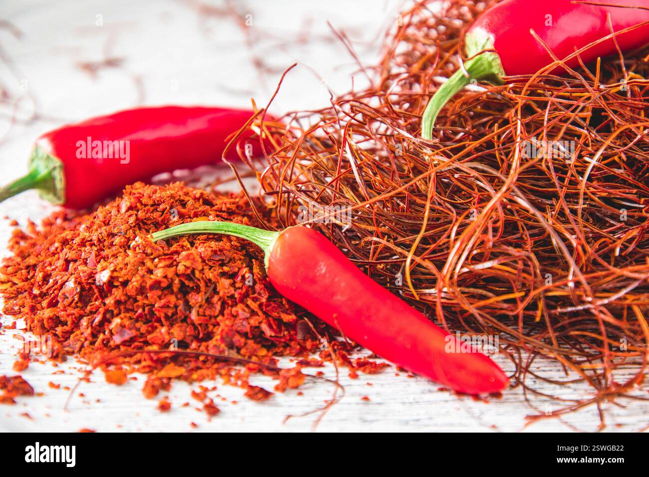 Gousses de piment, flocons et fils sur fond blanc, gros plan Banque D'Images