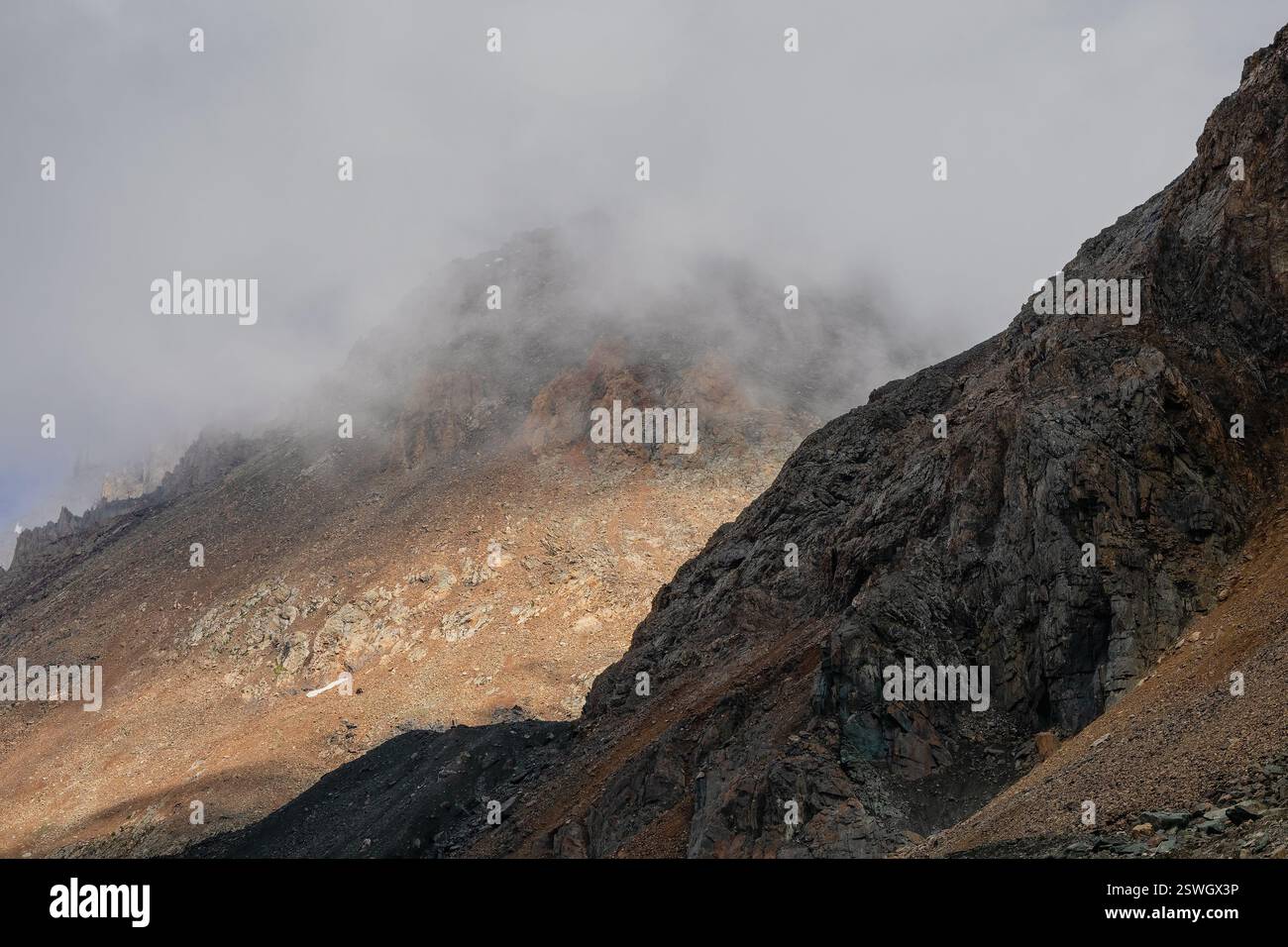 Paysage fantomatique atmosphérique avec des silhouettes floues de roches acérées dans des nuages bas. Vue spectaculaire sur les grandes montagnes floues en R. Banque D'Images