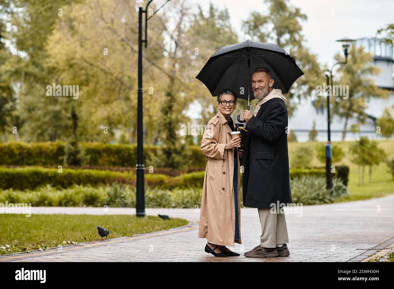 Un couple aimant partage une promenade chaleureuse et paisible ensemble loin de la pluie. Banque D'Images