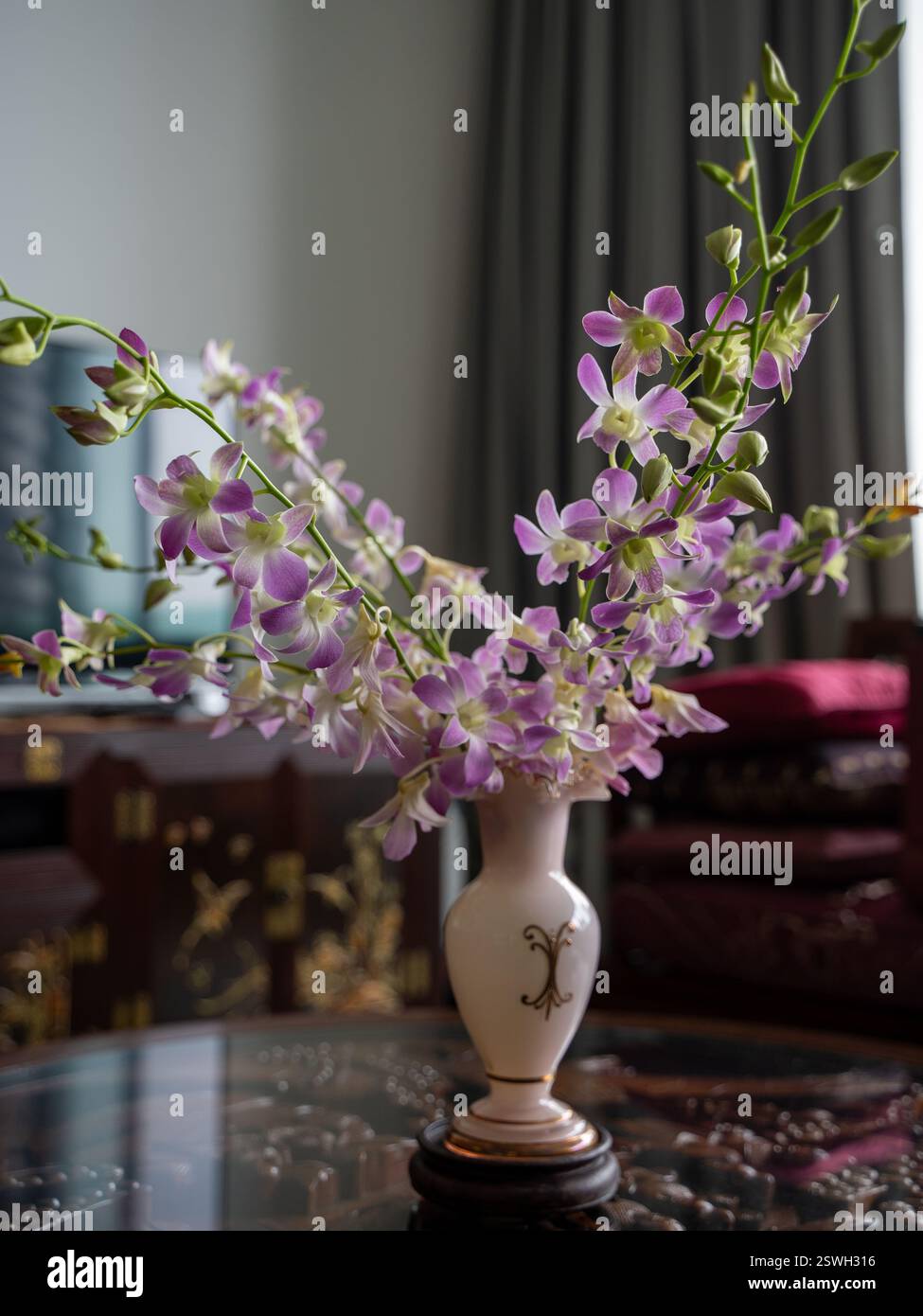 Un bel arrangement d'orchidée pourpre dans un vase élégant Banque D'Images