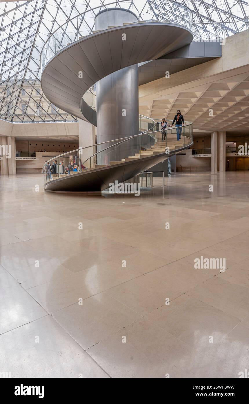 Paris, France - 02 23 2022 : Musée du Louvre. Le grand escalier en colimaçon et l'ascenseur sous la pyramide du Louvre dans le hall de réception Banque D'Images