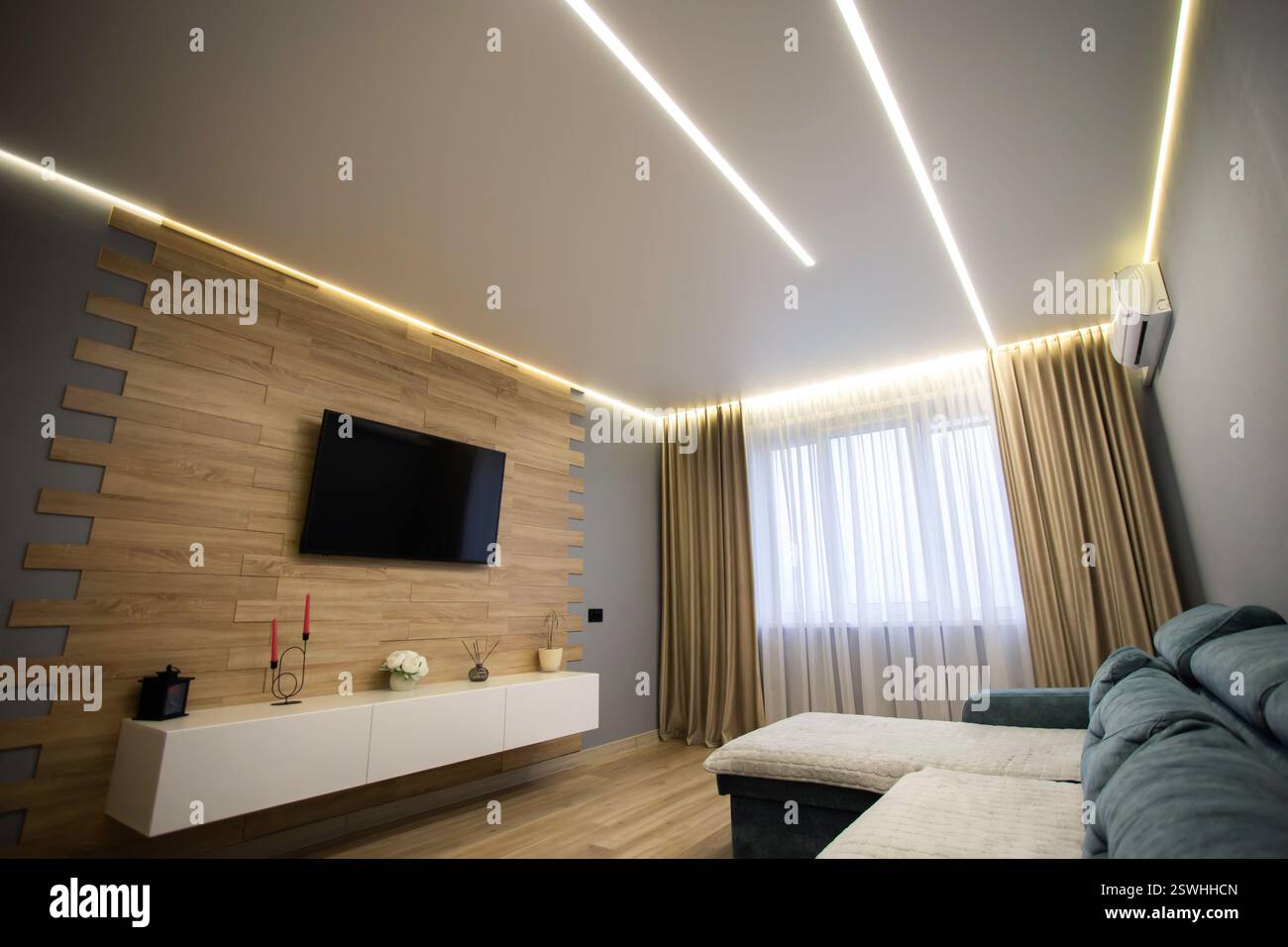 Intérieur moderne dans le salon avec parquet stratifié, armoires murales et télévision LCD. Plafond de diode étiré autour du périmètre. Copier spac Banque D'Images