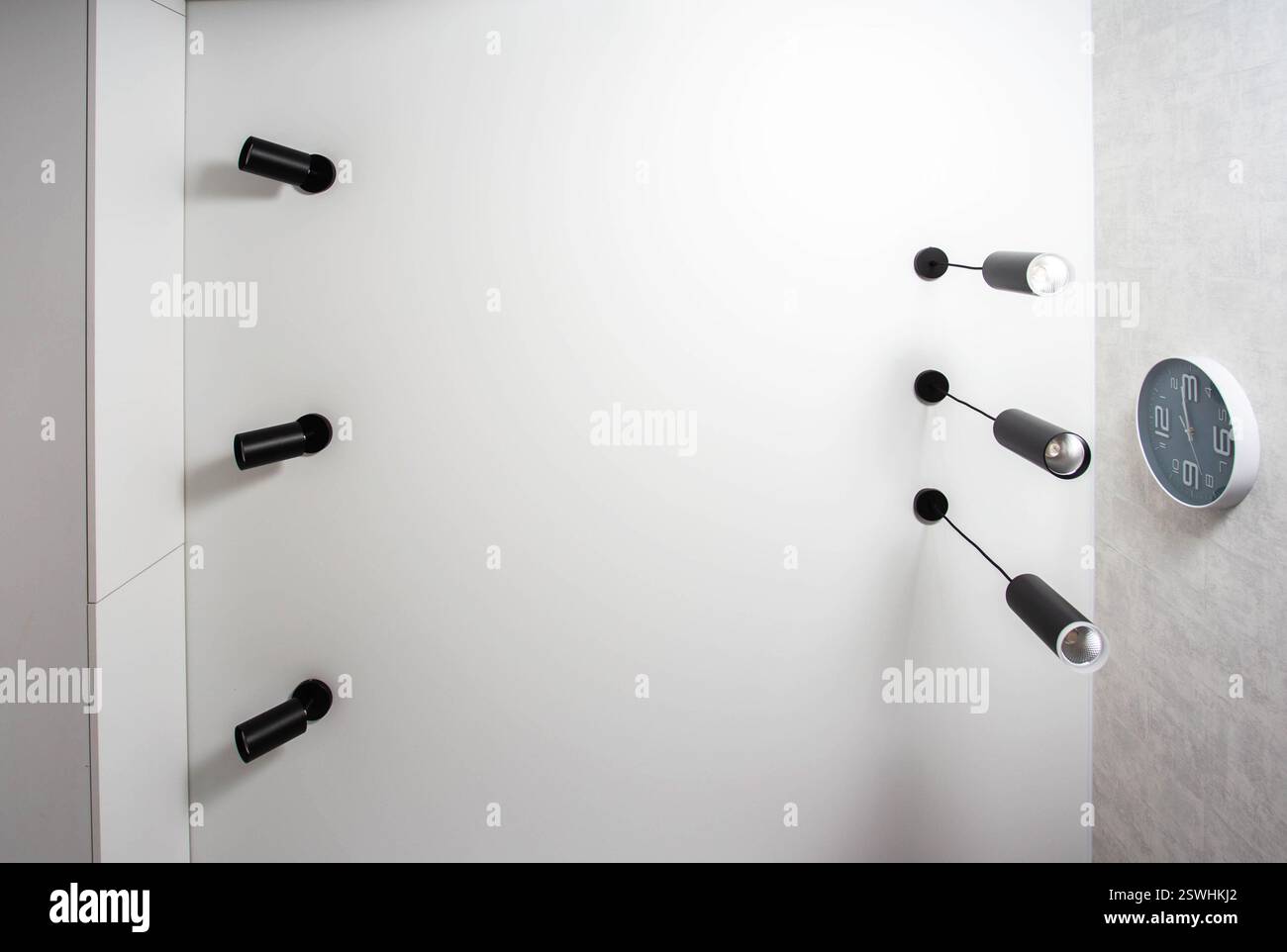 Plafond suspendu moderne avec différentes lampes LED noires sur un plafond blanc dans la cuisine. Copier l'espace pour le texte Banque D'Images