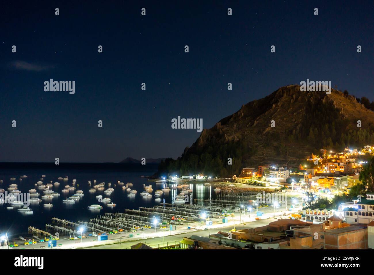 Vue nocturne panoramique du lac Titicaca avec des bateaux sur l'eau et un magnifique ciel étoilé de Copacabana Bolivie Banque D'Images