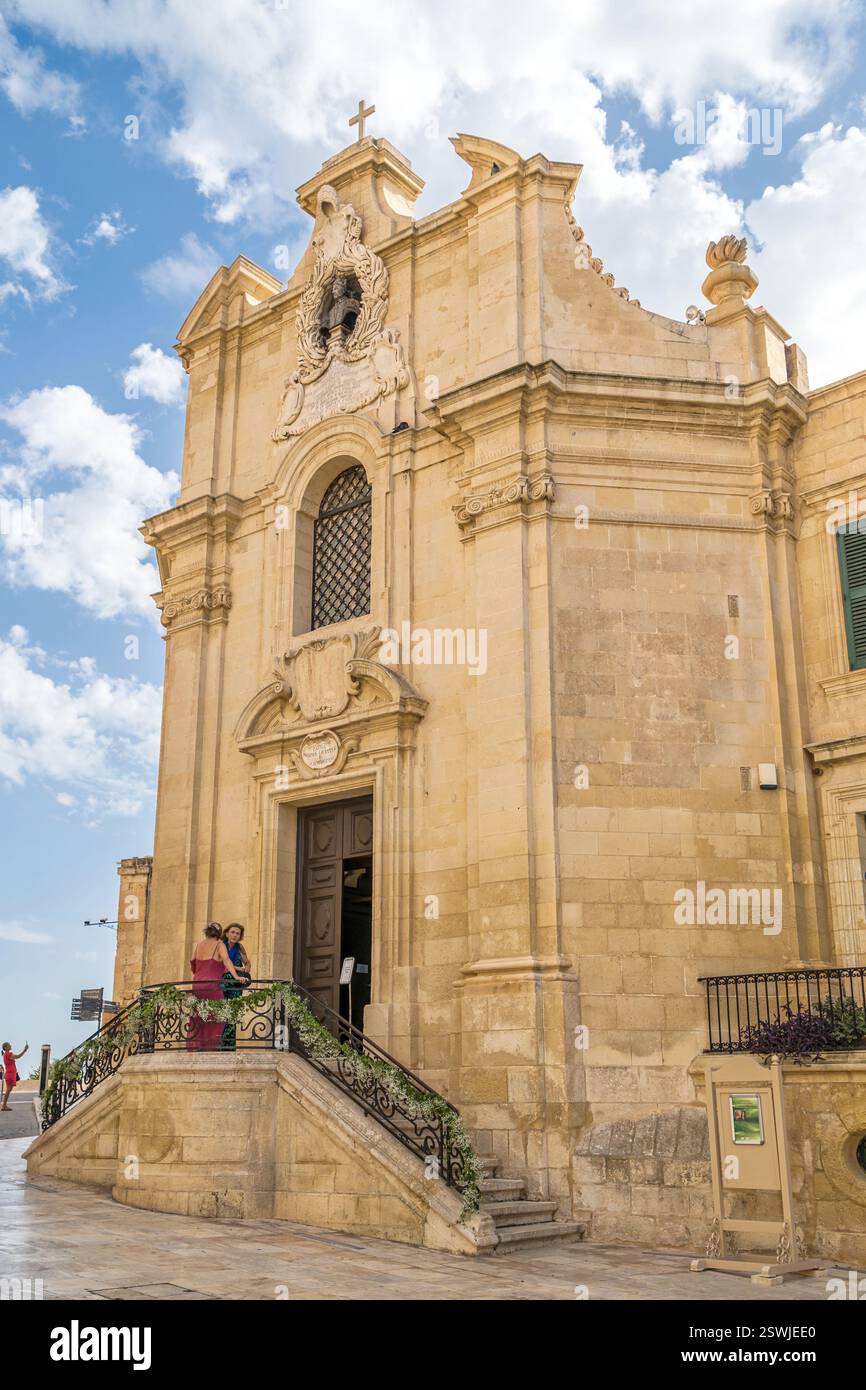 Entrée de l'église baroque avec guirlandes florales et escalier en pierre - la Valette, Malte. Banque D'Images