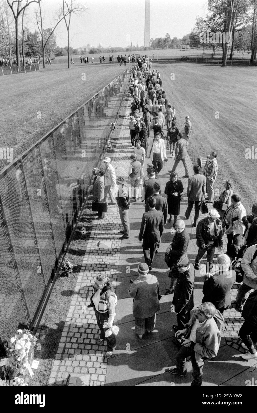Les gens se rassemblent autour du Mémorial des vétérans du Vietnam après la cérémonie de dévoilement de la statue des « trois combattants » sur Constitution Gardens, le 9 novembre 1984 à Washington, D.C. Banque D'Images