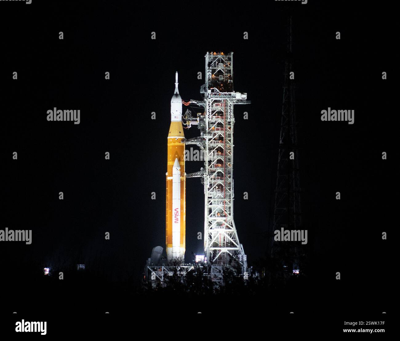 Une fusée Space Launch System (SLS) avec le vaisseau spatial Orion à bord est vue la nuit, éclairée par des projecteurs au sommet d'un lanceur mobile au Launch Complex 39B, le 18 mars 2022, après avoir été déployée pour la première fois au Kennedy Space Center de la NASA en Floride. Avant le test en vol Artemis I de la NASA, la fusée subira une répétition générale humide pour vérifier les systèmes et pratiquer les procédures de compte à rebours. Banque D'Images