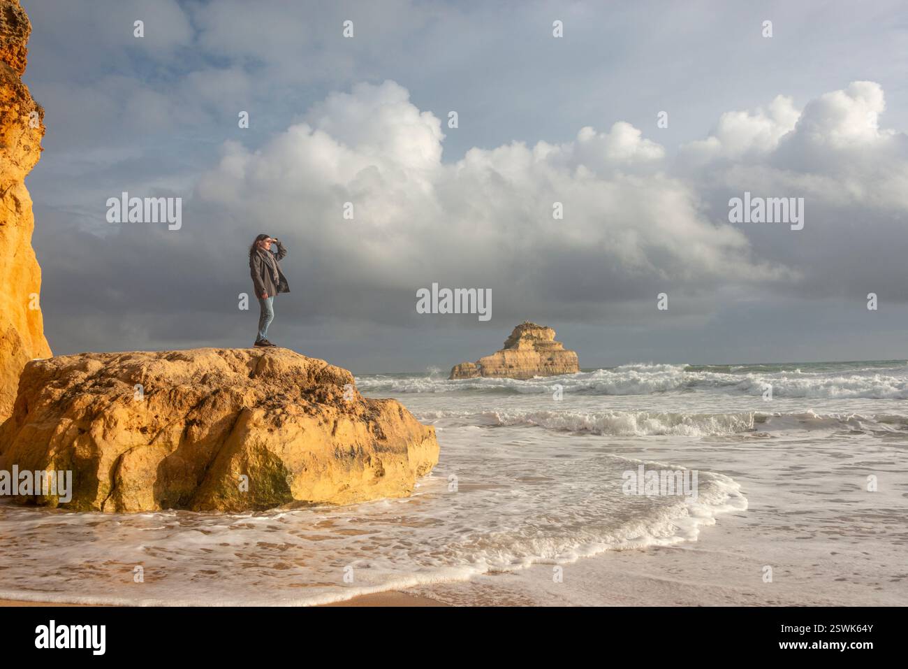 femme debout sur les rochers près de l'océan regardant les vagues et la vue Banque D'Images femme debout sur les rochers près de l'océan regardant les vagues et la vue Banque D'Images