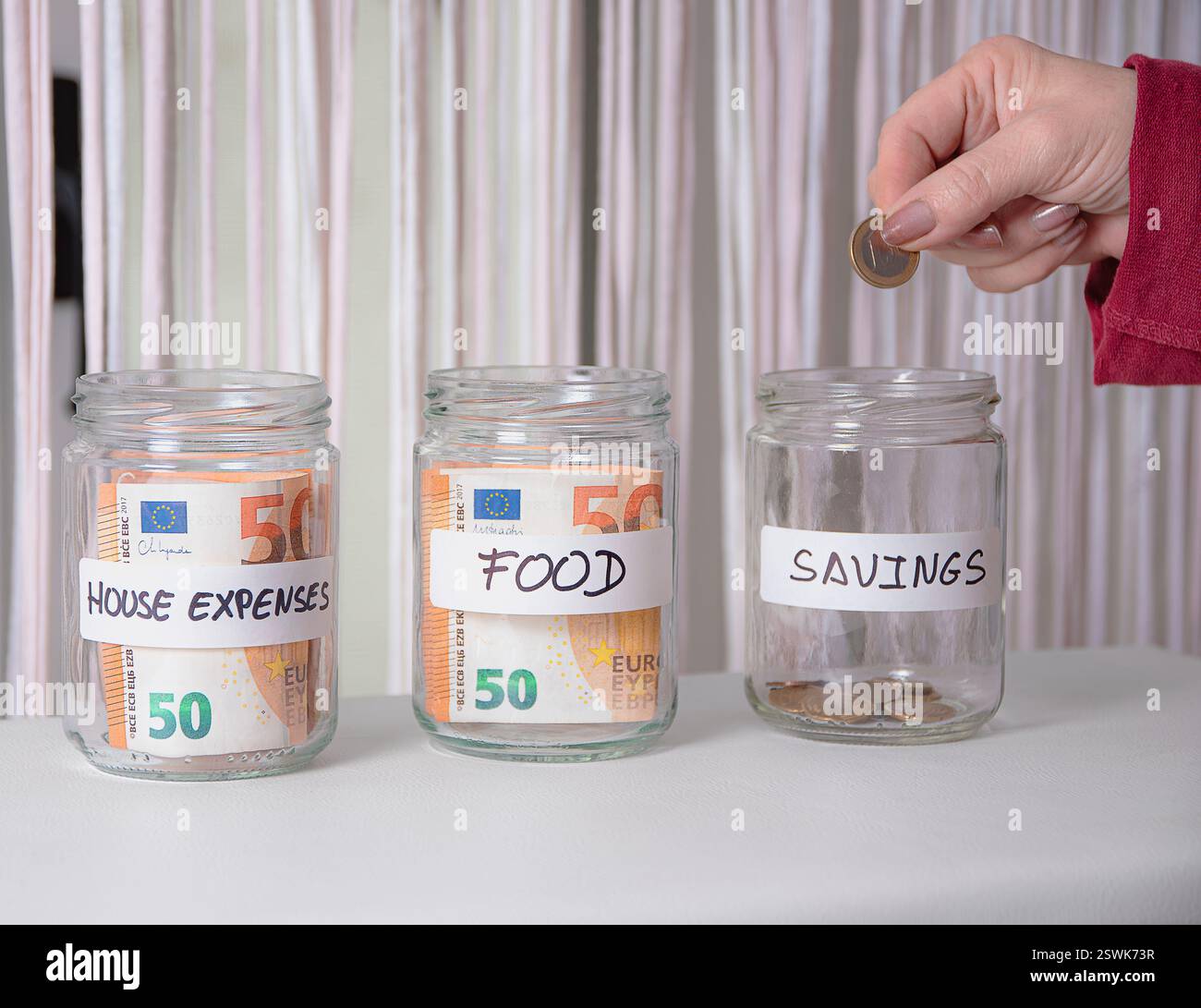 Contrôle domestique des dépenses mensuelles. Quelques pots en verre étiquetés avec de l'argent à l'intérieur pour les dépenses. Banque D'Images