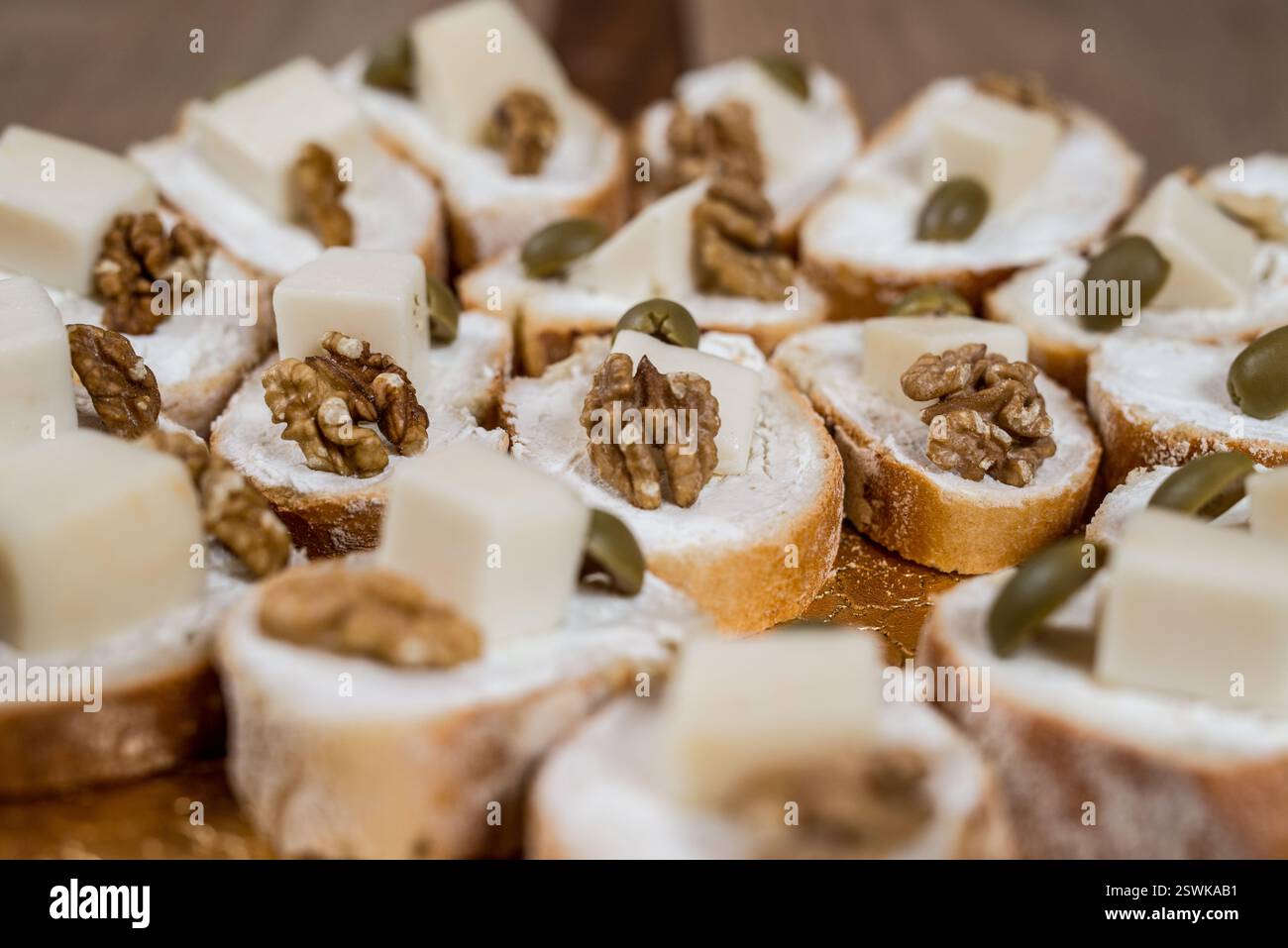 Un gros plan de canapés garni de noix de fromage et d'olives prêt pour un hors-d'œuvre délicieux et élégant Banque D'Images