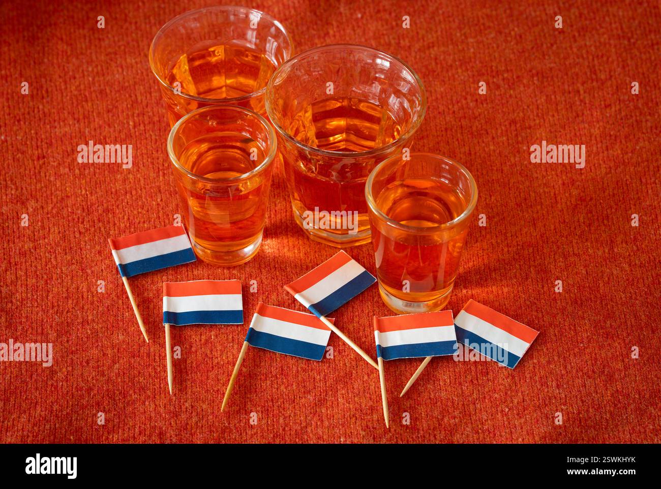 Célébration de la fête nationale du Roi aux pays-Bas, drapeau néerlandais et alcool traditionnel sur fond orange Banque D'Images