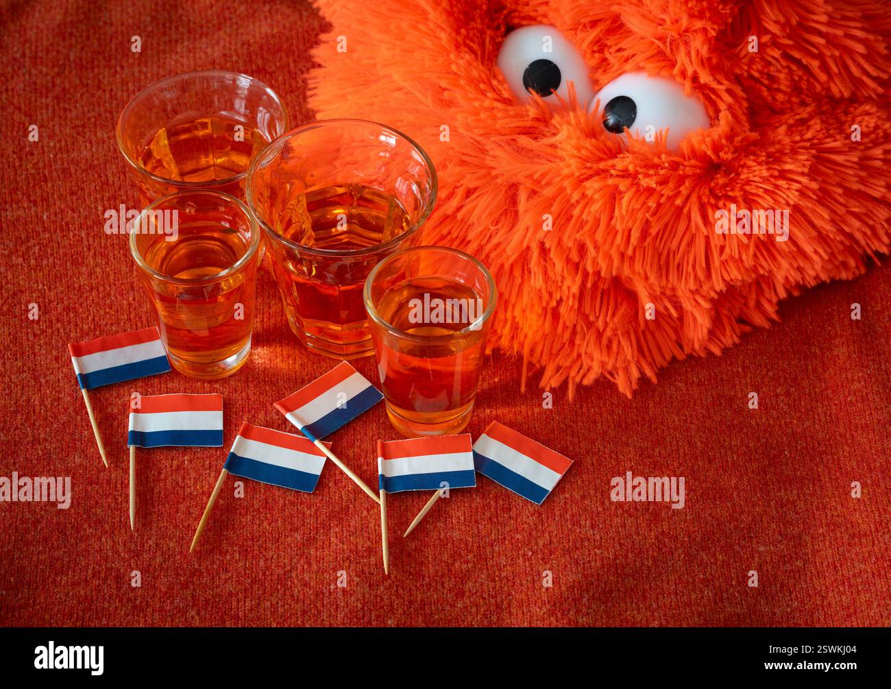 Célébration de la fête nationale du Roi aux pays-Bas, drapeau néerlandais et alcool traditionnel sur fond orange Banque D'Images
