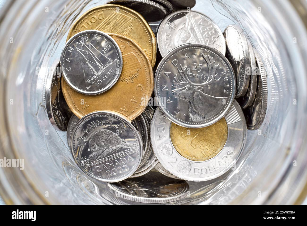 Regarder à l'intérieur du pot en verre avec des pièces d'argent canadiennes Banque D'Images