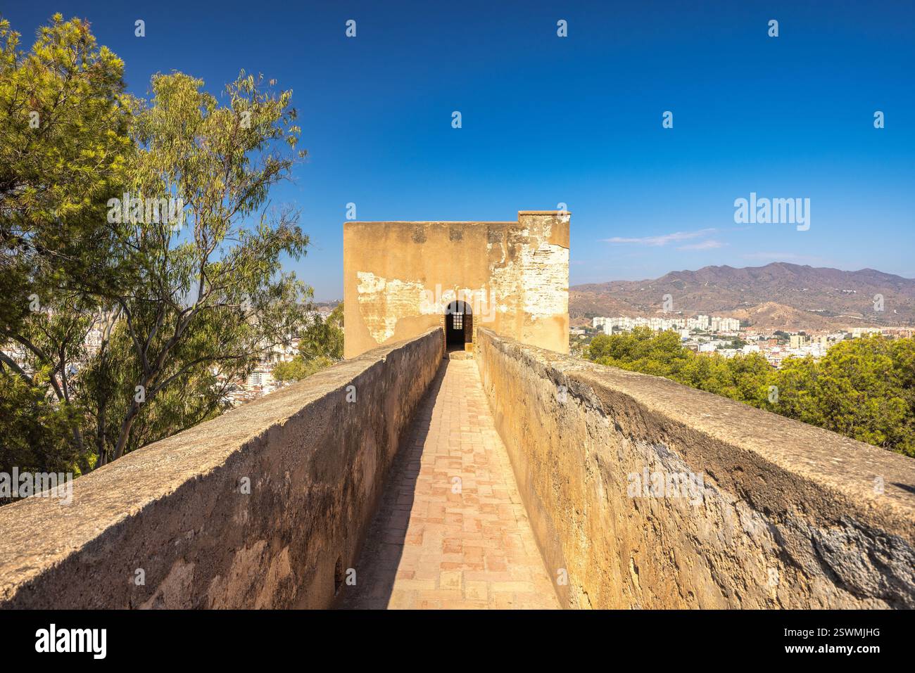Château de Gibralfaro dans la ville de Malaga en Andalousie, Espagne, Europe. Ancien chemin de pierre menant à une tour de forteresse, surplombant une ville lointaine et mou Banque D'Images