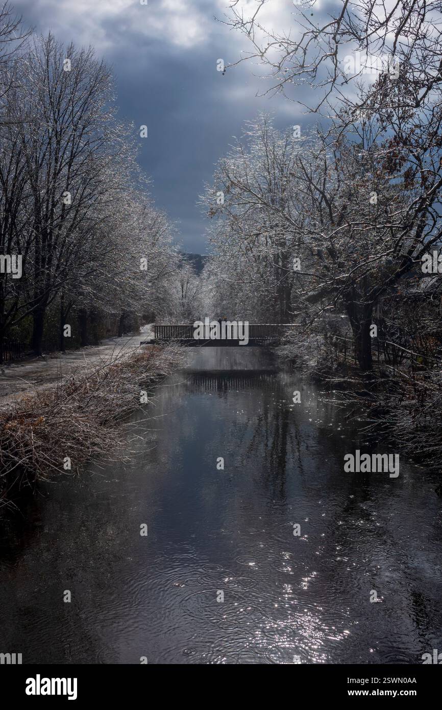 Lambertville, NJ, États-Unis - 9 février 2025 : les visiteurs marchent sur les sentiers du Delaware canal Trail pendant une froide journée d'hiver alors que les branches d'arbres scintillent dans le t Banque D'Images