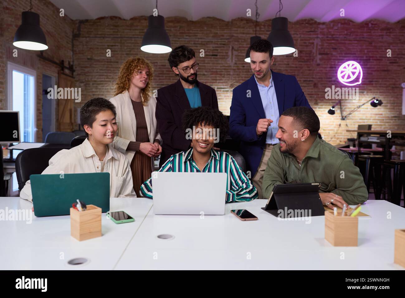 Équipe d'affaires diversifiée collaborant sur le projet à l'aide d'un ordinateur portable dans un bureau moderne Banque D'Images