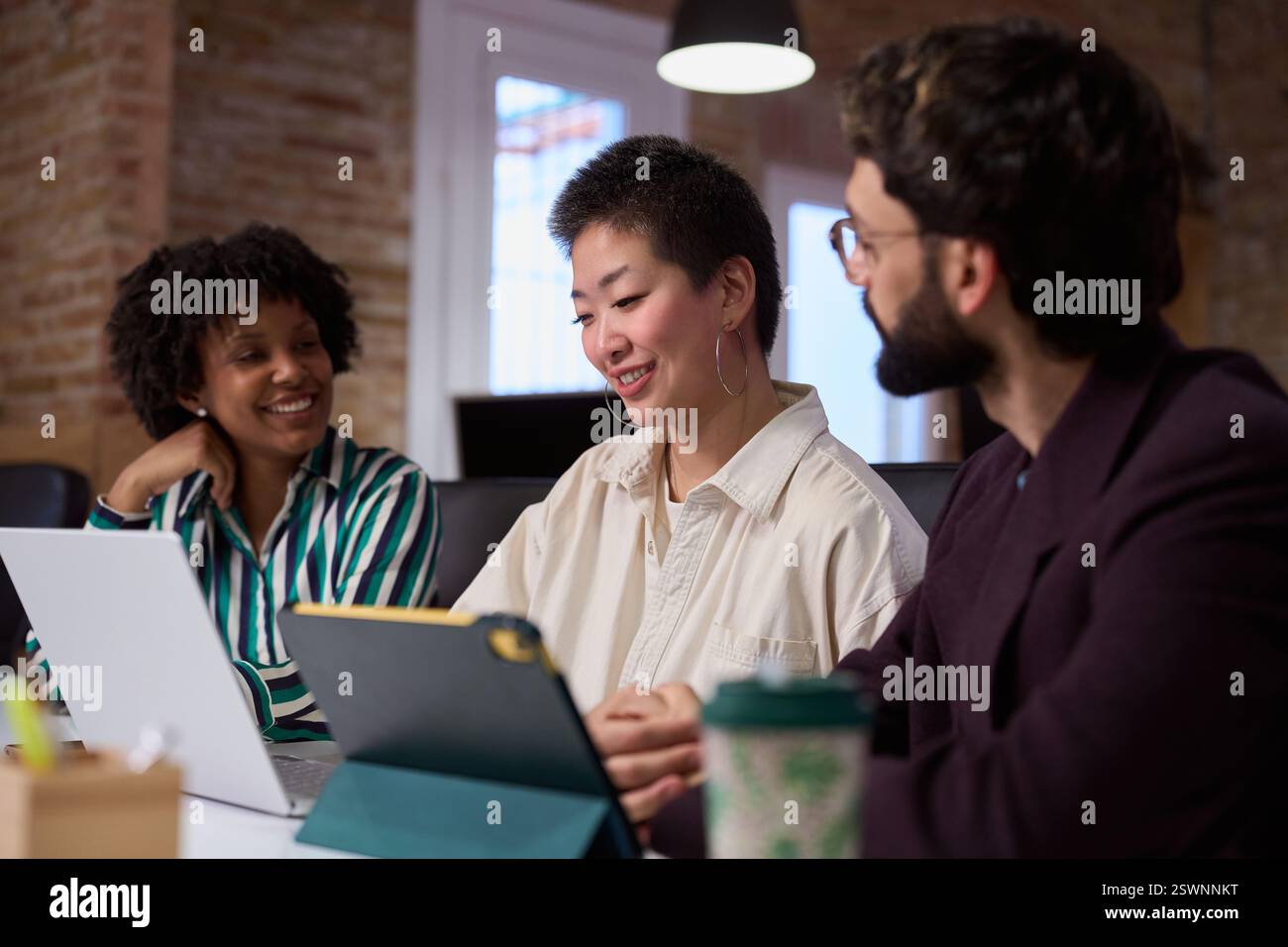 Des gens d'affaires travaillant ensemble sur un projet à l'aide d'une tablette numérique au bureau Banque D'Images