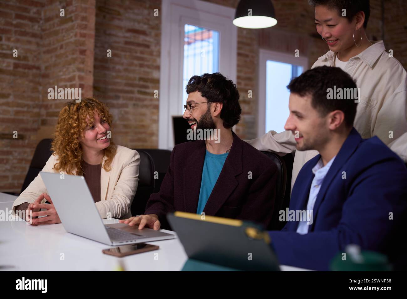 Équipe de démarrage discutant du projet sur ordinateur portable dans le bureau moderne Banque D'Images