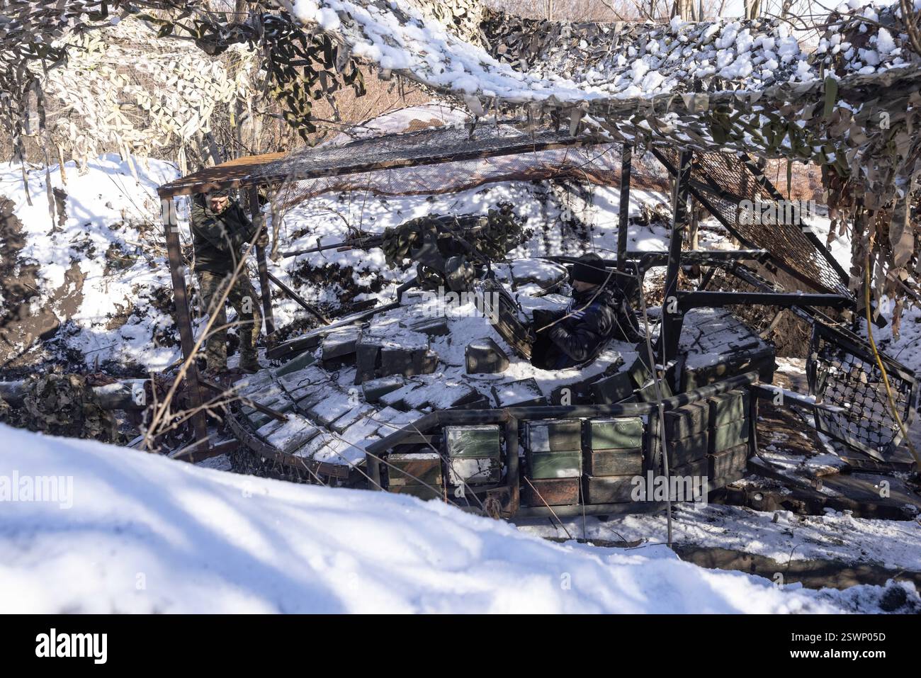 Marioupol, Ukraine. 22 février 2025. Camouflage d'un char T64 par l'équipage de la 56e brigade d'infanterie motorisée séparée de Marioupol en position fermée près du front dans la région de Donetsk. Peu avant le troisième anniversaire de la guerre en Ukraine lors des négociations de cessez-le-feu, le 21 février 2025. Photo. Par Yevhen Titov/ABACAPRESS. COM Credit : Abaca Press/Alamy Live News Banque D'Images