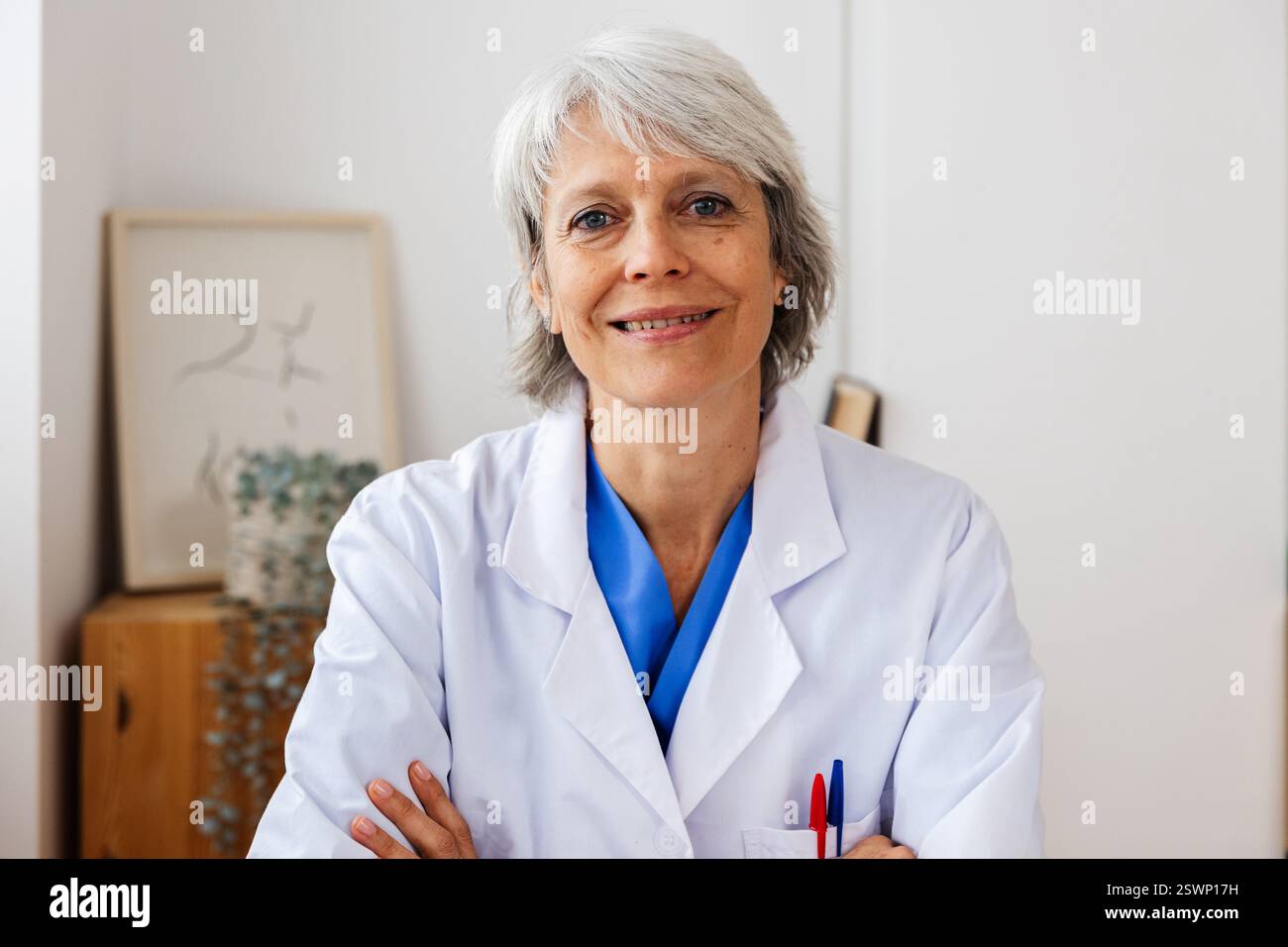 Portrait de femme médecin mature regardant la caméra assise sur le bureau au bureau Banque D'Images