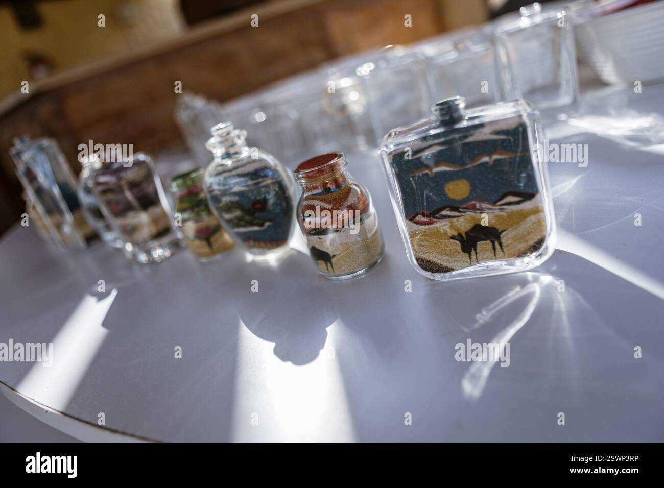 Bouteilles en verre remplies de sable coloré créant de belles représentations artistiques des paysages du désert égyptien, un souvenir traditionnel de marsa al Banque D'Images