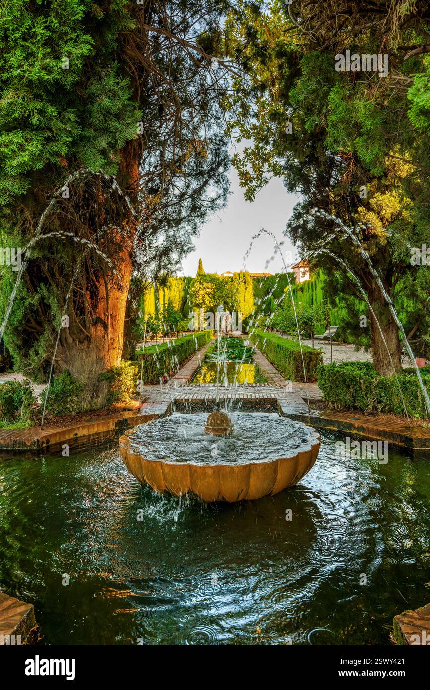 Exquise fontaine de l'Alhambra arquée par la splendeur Evergreen : un aperçu intemporel des majestueux jardins du Generalife de Grenade embrassés par des siècles d'histoire Banque D'Images