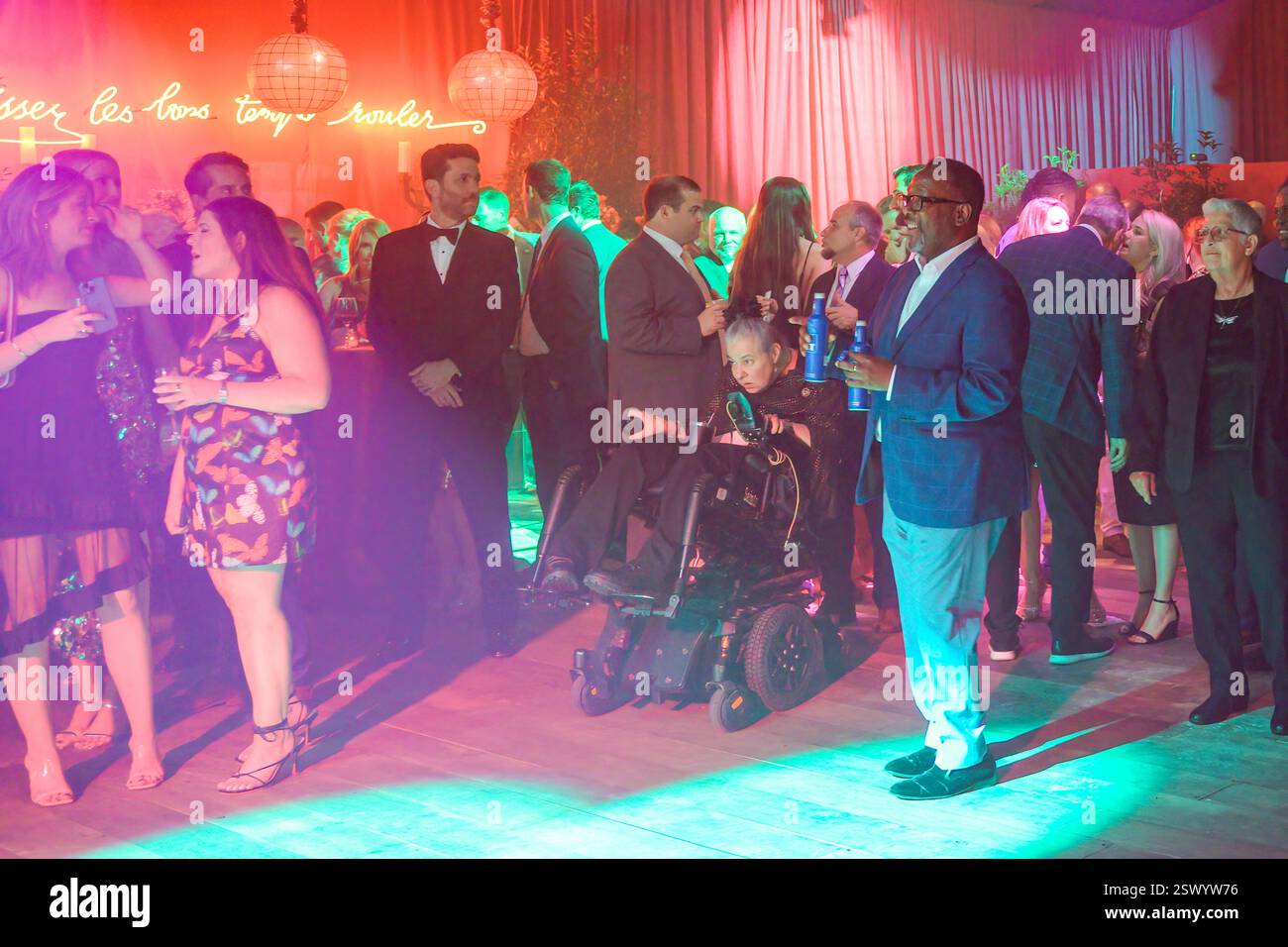 New Orleans, LOUISIANE, États-Unis - 8 février 2025 : Fête foule sous les lumières colorées à la fête LIX pré Super Bowl de Gayle Benson dans la structure temporaire du parc de la ville avec l'acteur Wendall Pierce sur la droite. Banque D'Images
