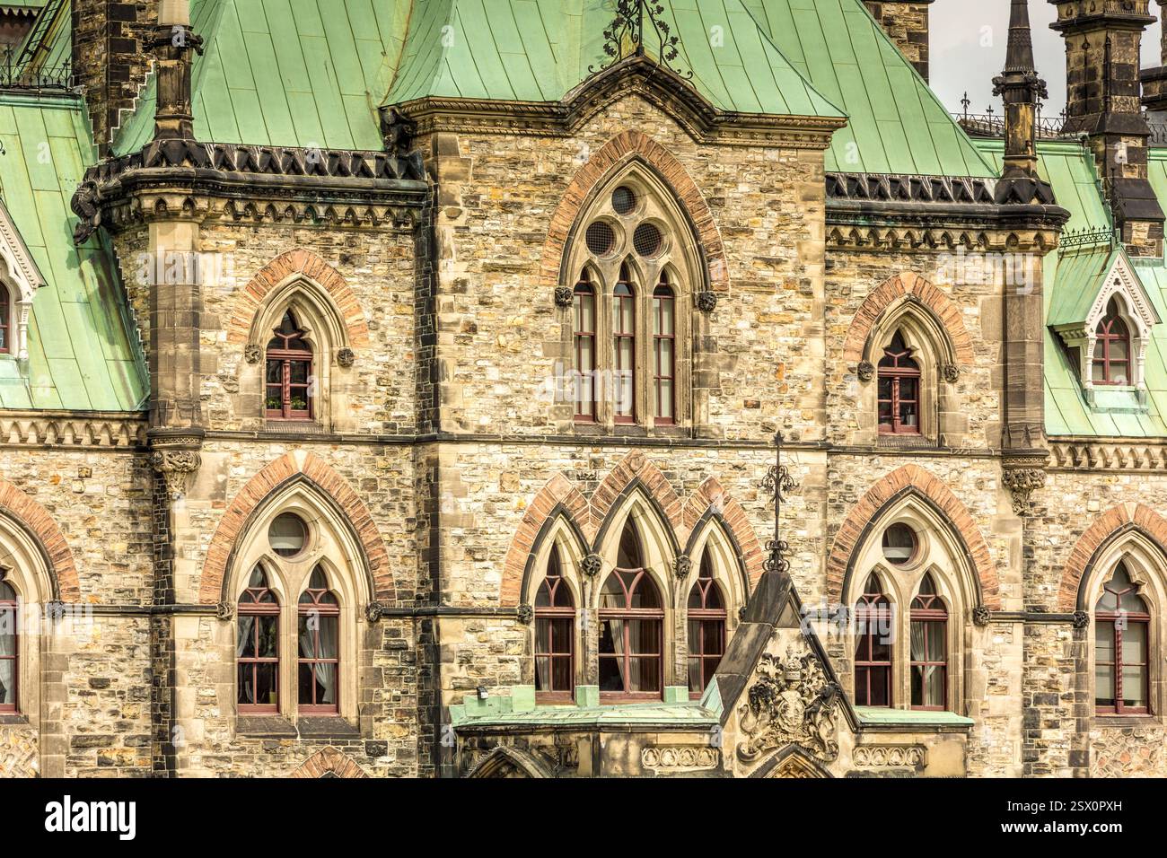 Bâtiment avec un toit vert et beaucoup de fenêtres. Les fenêtres sont cintrées et le bâtiment est très vieux Banque D'Images